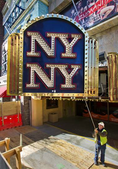 Yesco’s Kent Faddi slowly steers the New York - New York Hotel & Casino marquee entrance sign as it’s taken down  and donated to the Neon Museum on Tuesday, Jan. 7, 2014.